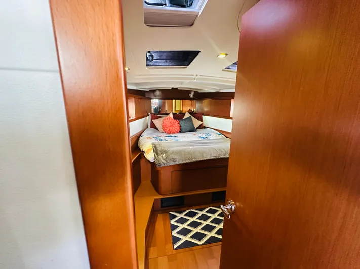 “imagine That” Yacht Photos Pics Cozy cabin interior of 2015 Beneteau Oceanis 45 sailboat with bed and wooden finish.
