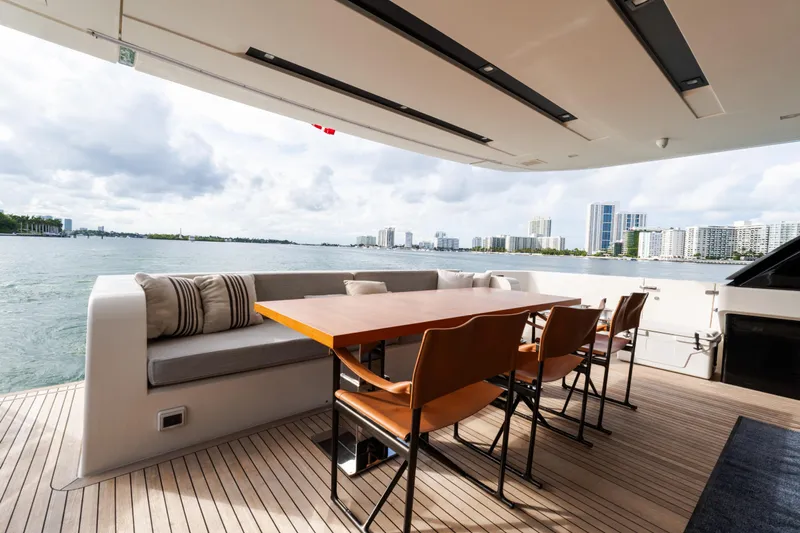 Gatsby Yacht Photos Pics Luxurious Sanlorenzo SL96 yacht deck with dining area, overlooking waterfront cityscape, 2021 model.