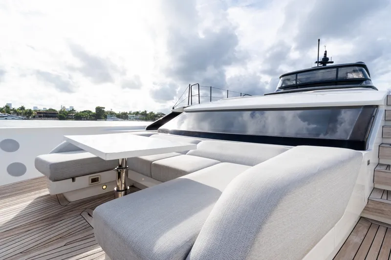 Gatsby Yacht Photos Pics Luxurious 2021 Sanlorenzo SL96 yacht deck with modern seating and table, under cloudy sky.