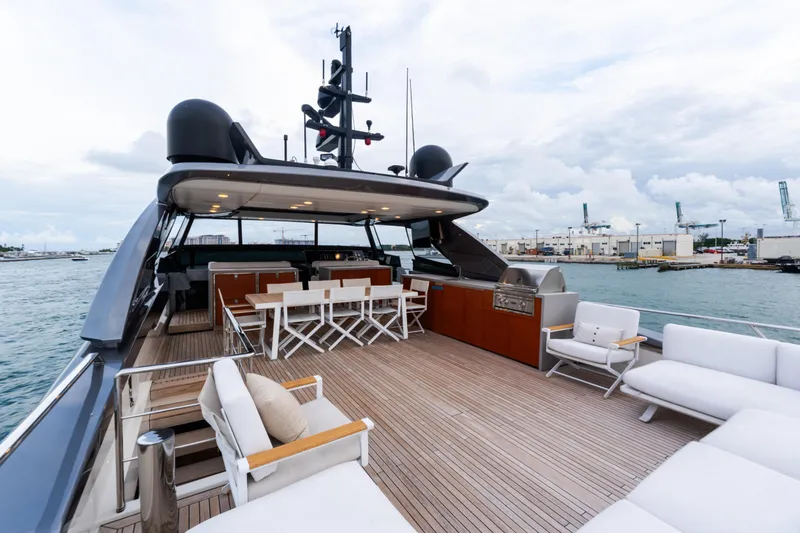 Gatsby Yacht Photos Pics Luxurious 2021 Sanlorenzo SL96 yacht deck with seating and dining area, docked at a marina.