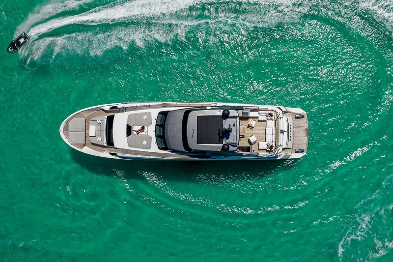 Gatsby Yacht Photos Pics Aerial view of 2021 Sanlorenzo SL96 yacht on turquoise water with jet ski nearby.