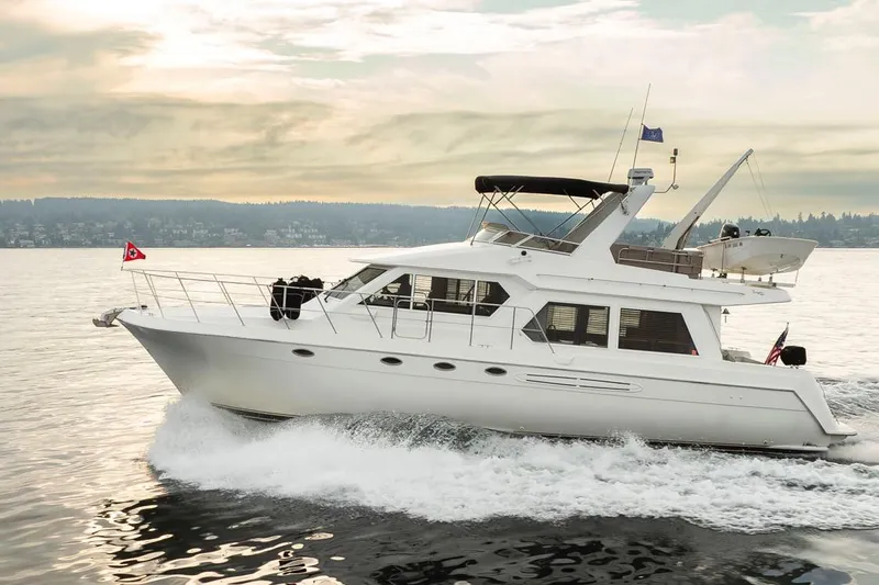 Y Knot Yacht Photos Pics 2003 Navigator 4800 yacht cruising on a serene lake at sunset.