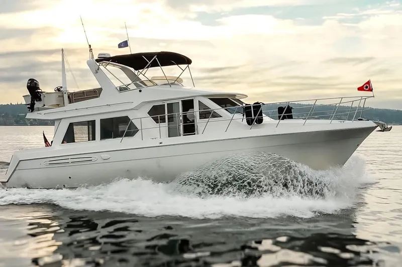 Y Knot Yacht Photos Pics 2003 Navigator 4800 yacht cruising on calm waters at sunset.