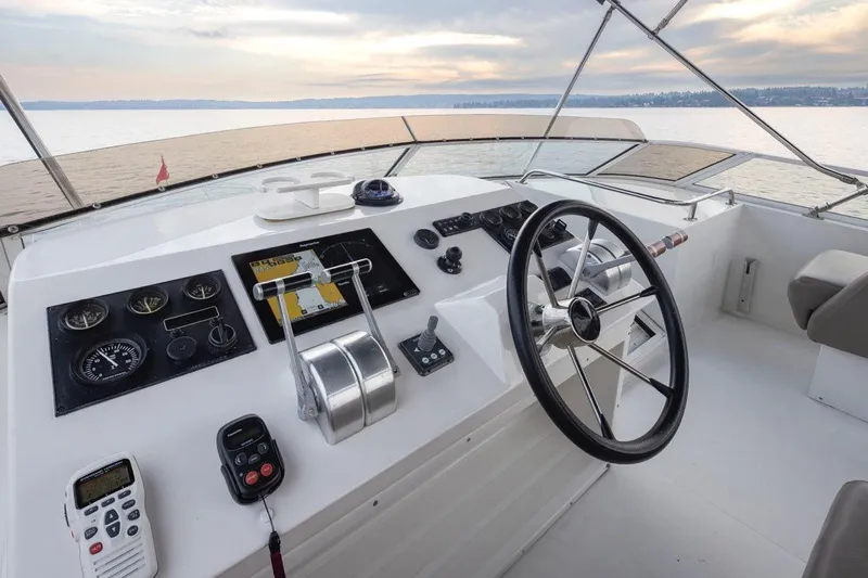 Y Knot Yacht Photos Pics Helm of 2003 Navigator 4800 yacht with steering wheel and navigation controls.