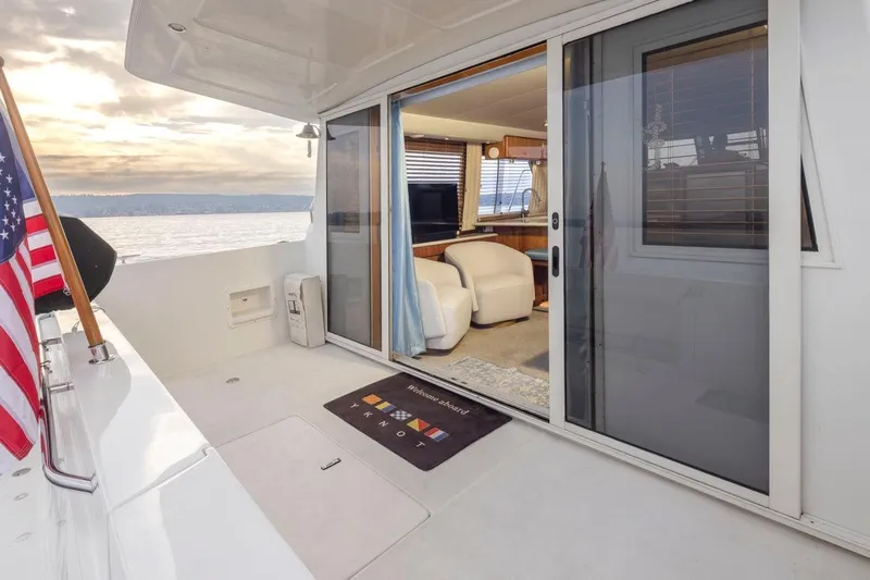Y Knot Yacht Photos Pics 2003 Navigator 4800 yacht interior with sliding glass doors and American flag on deck.