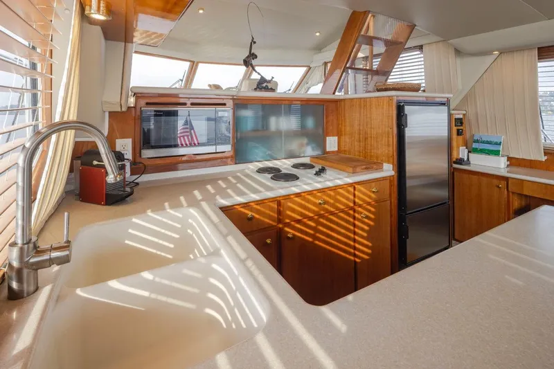 Y Knot Yacht Photos Pics Luxurious 2003 Navigator 4800 yacht kitchen with modern appliances and elegant wood cabinetry.