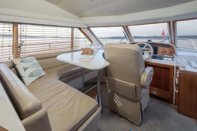 Y Knot Yacht Photos Pics Luxurious 2003 Navigator 4800 yacht interior with plush seating and helm, overlooking serene waters.