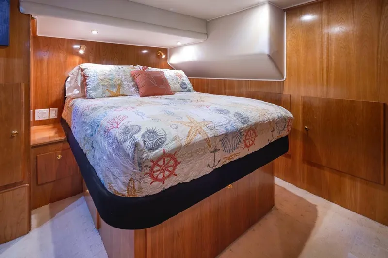 Y Knot Yacht Photos Pics Luxurious bedroom interior of 2003 Navigator 4800 yacht with nautical-themed bedding.