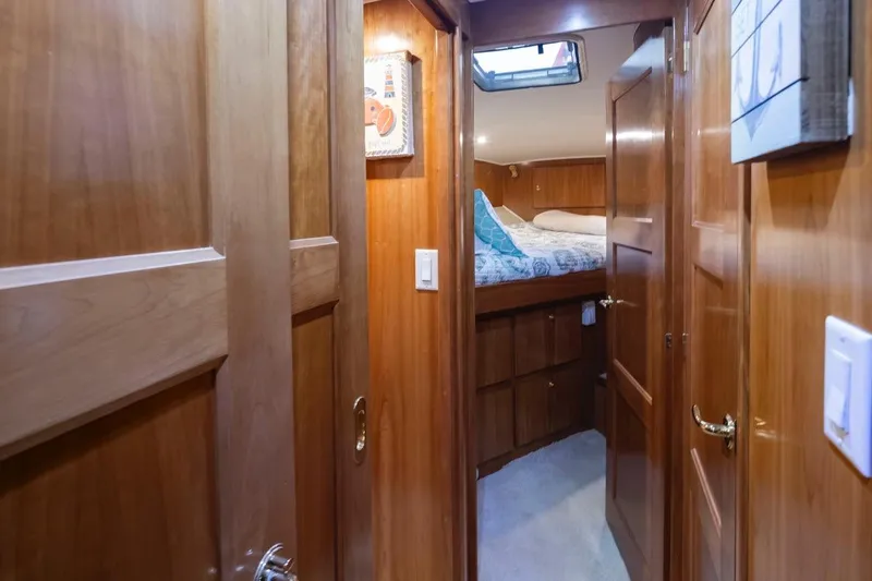 Y Knot Yacht Photos Pics Interior of 2003 Navigator 4800 yacht with wooden paneling and cozy bedroom.