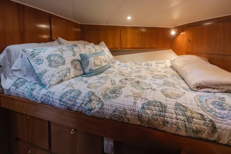 Y Knot Yacht Photos Pics Cozy cabin bedroom in 2003 Navigator 4800 yacht with seashell-themed bedding.
