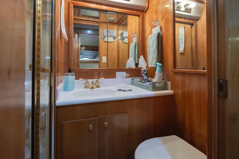 Y Knot Yacht Photos Pics Luxurious 2003 Navigator 4800 yacht bathroom with wood cabinetry and modern amenities.