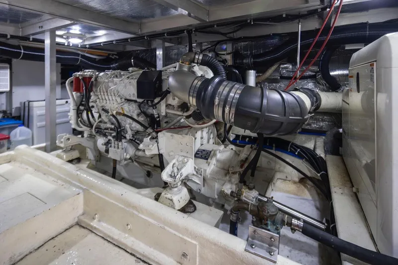 Y Knot Yacht Photos Pics Engine room of a 2003 Navigator 4800 yacht, showcasing mechanical components and piping.