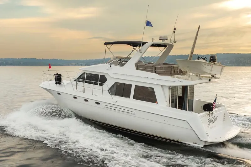 Y Knot Yacht Photos Pics 2003 Navigator 4800 yacht cruising on calm waters at sunset.
