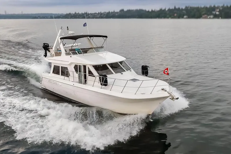 Y Knot Yacht Photos Pics 2003 Navigator 4800 yacht cruising on a calm lake, creating a wake.