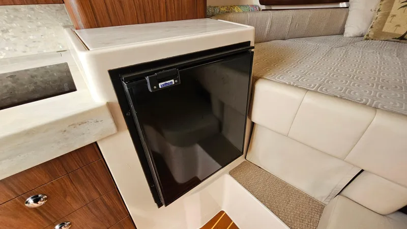  Yacht Photos Pics Compact refrigerator in 2016 Grady-White Express 330 boat interior, near cushioned seating.