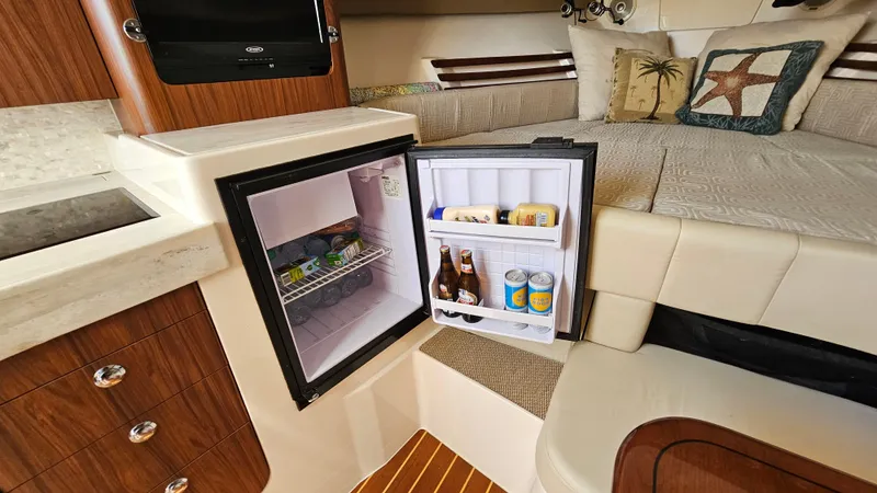  Yacht Photos Pics Interior of 2016 Grady-White Express 330 with open mini fridge and cozy seating area.