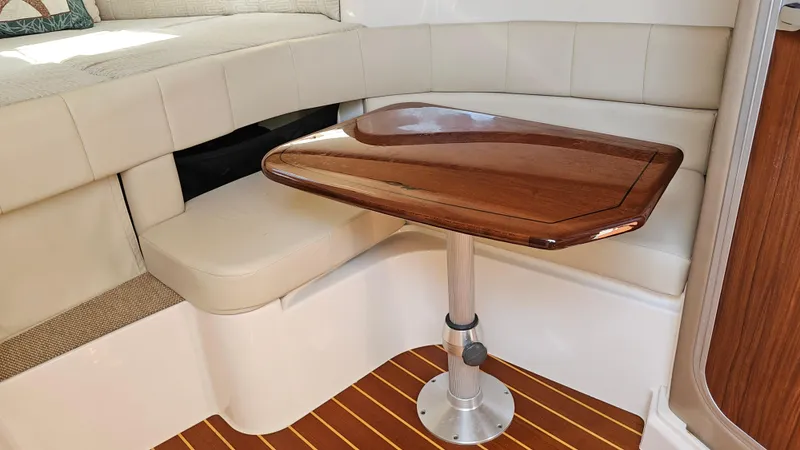  Yacht Photos Pics 2016 Grady-White Express 330 interior with wooden table and cushioned seating.