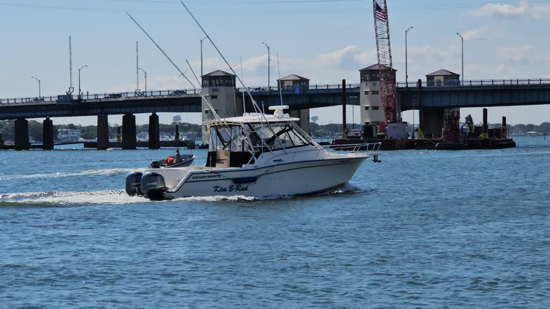  Yacht Photos Pics 2016 Grady-White Express 330 boat cruising near a bridge on a sunny day.