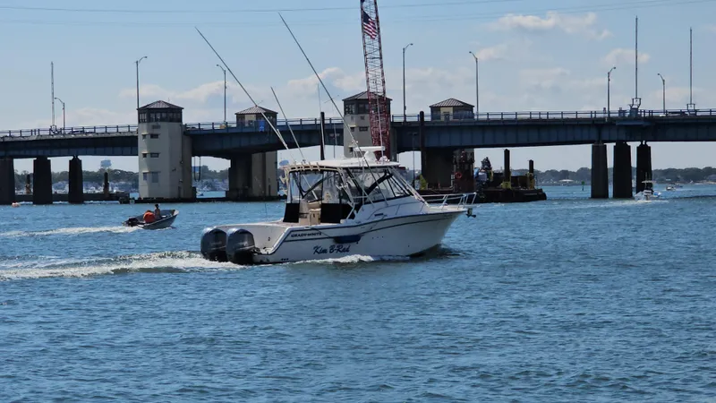  Yacht Photos Pics 2016 Grady-White Express 330 boat cruising near a bridge on a sunny day.