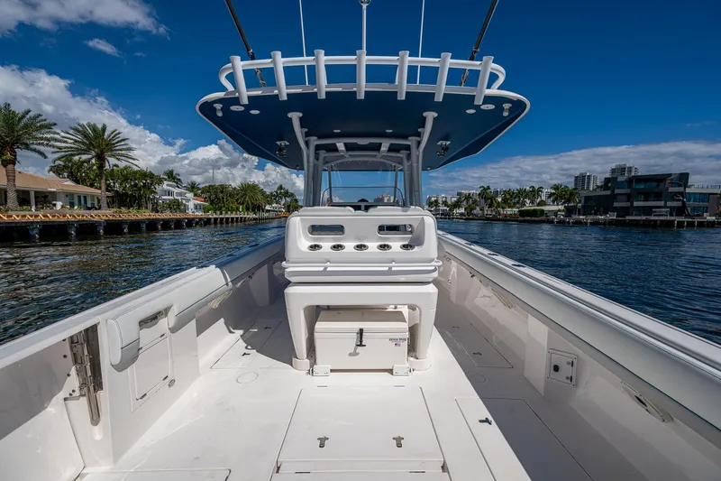  Yacht Photos Pics 2019 Intrepid 400 boat interior with helm, docked by waterfront homes under blue sky.