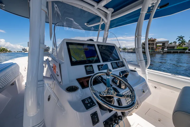  Yacht Photos Pics 2019 Intrepid 400 boat cockpit with advanced navigation system and steering wheel, docked by waterfront homes.