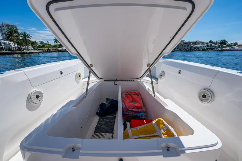  Yacht Photos Pics 2019 Intrepid 400 boat storage compartment with life jackets and gear, open on a sunny day.