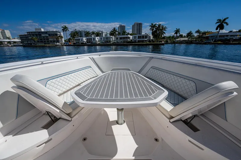  Yacht Photos Pics 2019 Intrepid 400 boat interior with seating and table, overlooking waterfront cityscape.