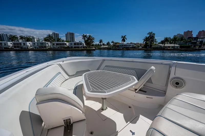  Yacht Photos Pics Luxurious 2019 Intrepid 400 boat interior with seating and table, overlooking waterfront cityscape.