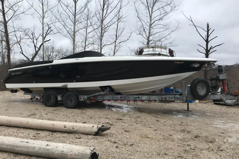  Yacht Photos Pics 2004 Cobalt 343 boat on trailer, parked outdoors near leafless trees.