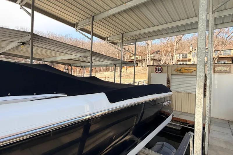  Yacht Photos Pics 2004 Cobalt 343 boat docked under covered marina, surrounded by trees and buildings.