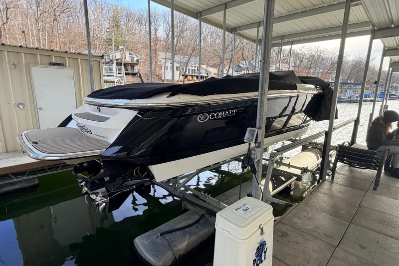  Yacht Photos Pics 2004 Cobalt 343 boat docked under a covered marina, partially covered with a black tarp.