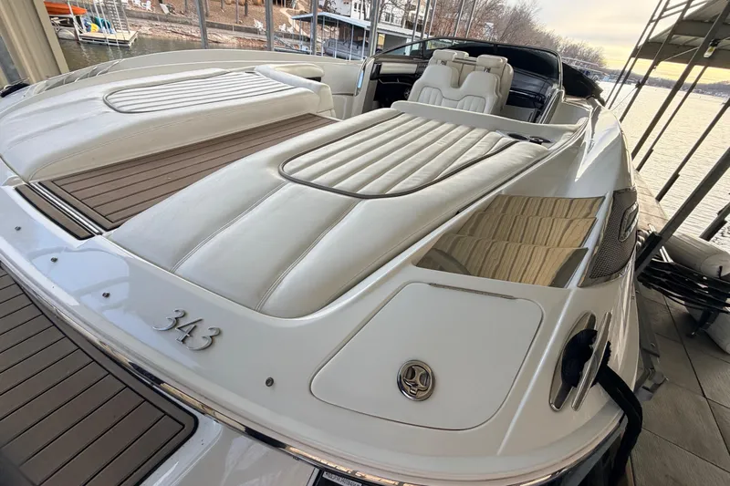  Yacht Photos Pics 2004 Cobalt 343 boat with white leather seating, docked by a serene lakeside.