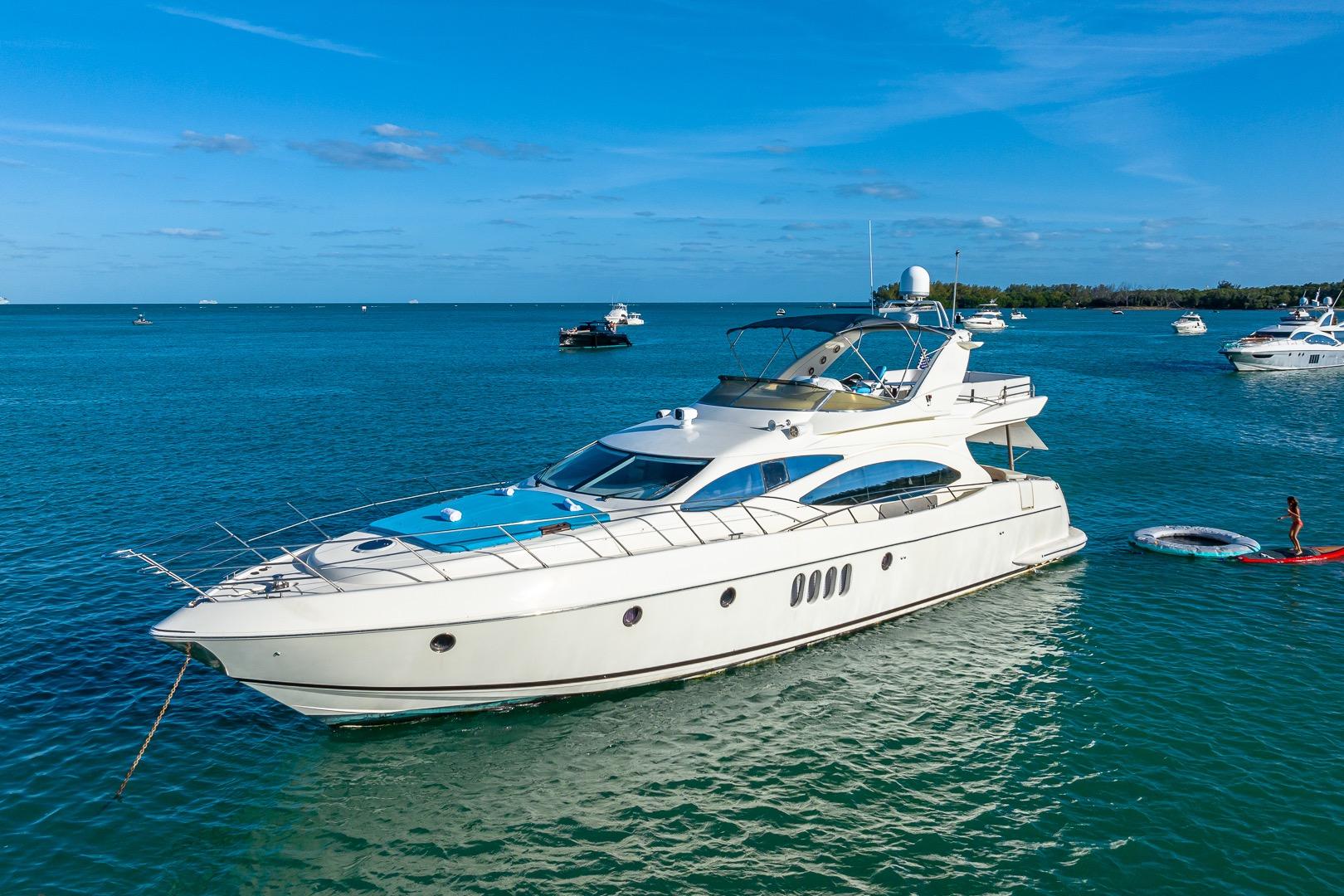 Azimut Fly 68 yacht from 2003 on serene blue waters, surrounded by other boats.