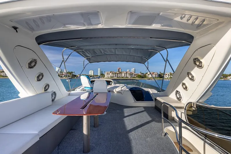 "pony Up" Yacht Photos Pics Luxurious 2003 Azimut Fly 68 yacht interior with seating and table, overlooking waterfront skyline.