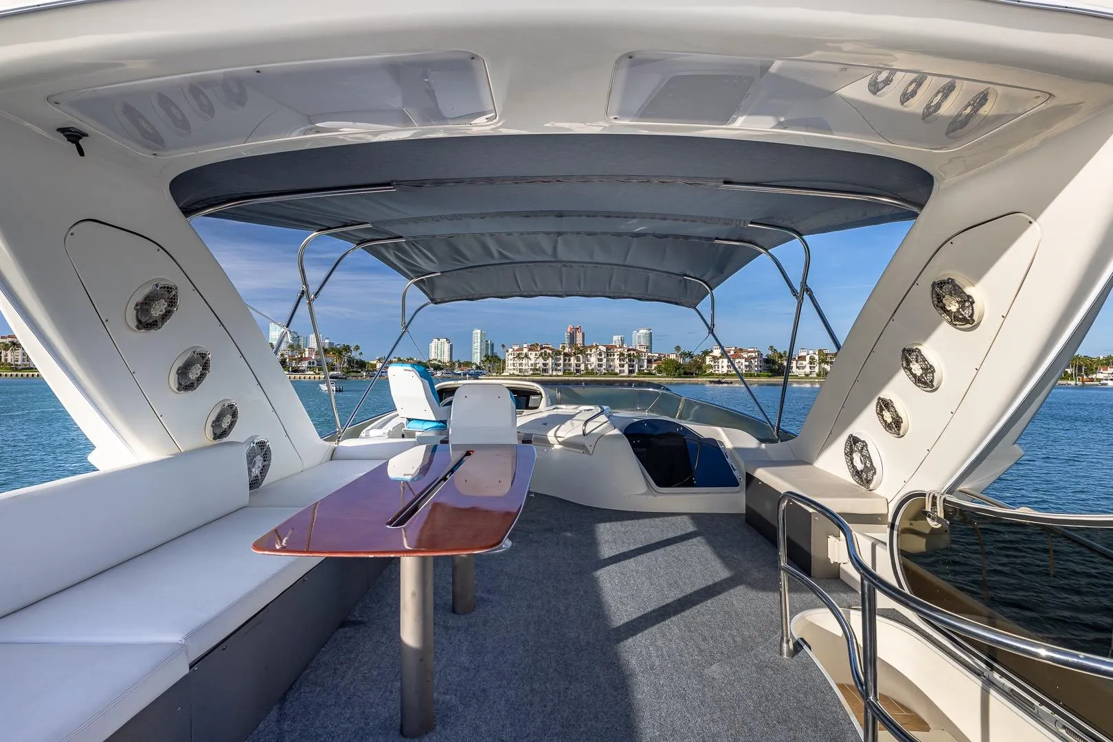 Luxurious 2003 Azimut Fly 68 yacht interior with seating and table, overlooking waterfront skyline.