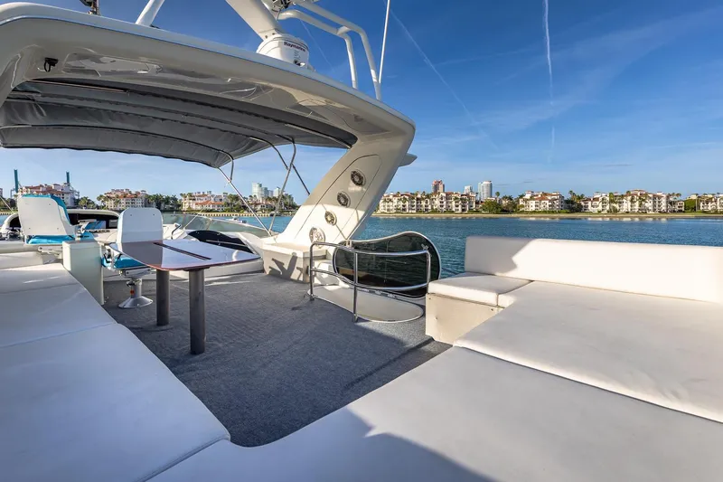 "pony Up" Yacht Photos Pics Luxurious 2003 Azimut Fly 68 yacht deck with seating, table, and waterfront view.