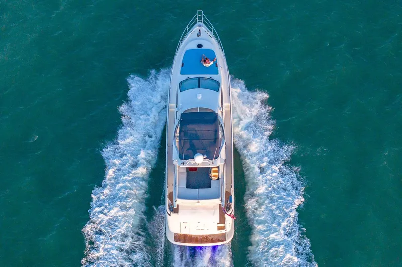 "pony Up" Yacht Photos Pics Aerial view of 2003 Azimut Fly 68 yacht cruising on open water.