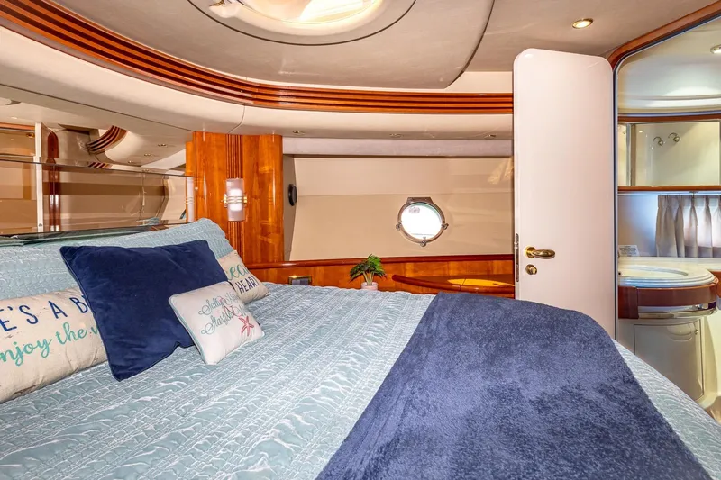 "pony Up" Yacht Photos Pics Luxurious bedroom interior of 2003 Azimut Fly 68 yacht with elegant bedding and porthole.