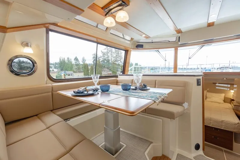  Yacht Photos Pics Luxurious interior of 2025 Ranger Tugs 43 Command Bridge with dining area and scenic views.