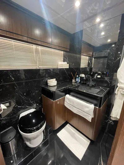 Blade Yacht Photos Pics Luxurious yacht bathroom with black marble, modern fixtures, and wooden cabinetry in a 2007 Pantera 80 GT.