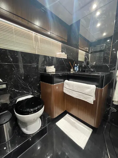 Blade Yacht Photos Pics Luxurious bathroom with black marble, wooden cabinetry, and modern fixtures in a 2007 Pantera 80 GT.