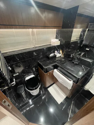 Blade Yacht Photos Pics Luxurious bathroom with black marble, modern fixtures, and wooden accents in a 2007 Pantera 80 GT.