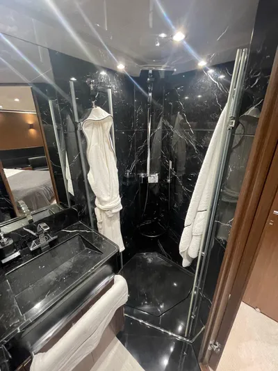 Blade Yacht Photos Pics Luxurious black marble bathroom in 2007 Pantera 80 GT yacht, featuring modern fixtures and robes.