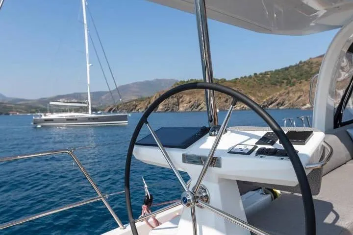  Yacht Photos Pics 2022 Jeanneau 60 yacht steering wheel with scenic ocean view in the background.