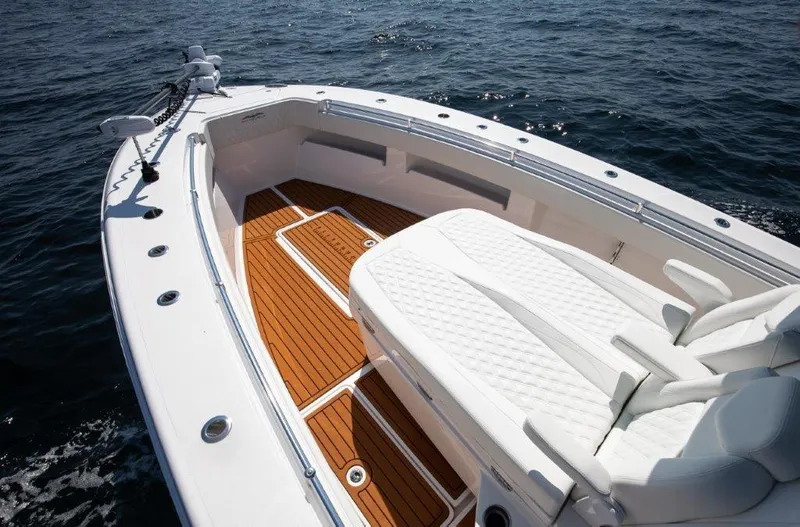  Yacht Photos Pics 2023 Invincible 36 Open boat with white seating and teak deck on the water.