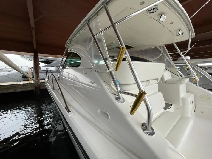  Yacht Photos Pics 2002 Pursuit 3800 Express boat docked under a wooden shelter.