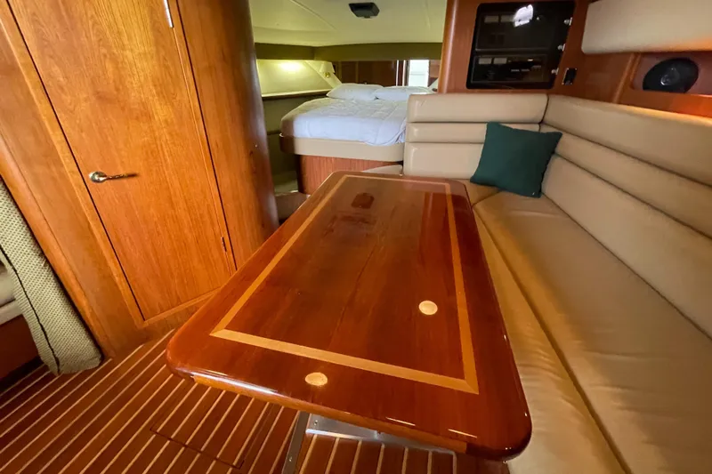  Yacht Photos Pics Interior of 2002 Pursuit 3800 Express yacht with wooden table and beige seating.