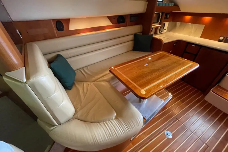  Yacht Photos Pics Luxurious interior of 2002 Pursuit 3800 Express yacht with leather seating and wooden table.