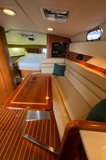  Yacht Photos Pics Luxurious interior of 2002 Pursuit 3800 Express yacht with wood finishes and cozy seating.