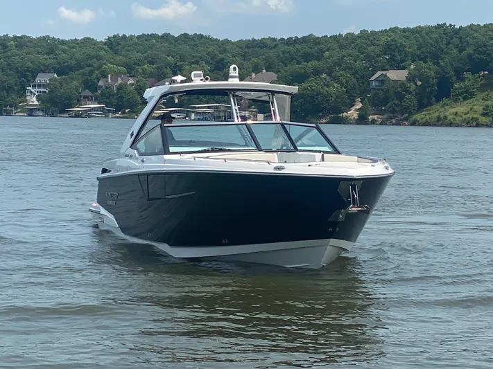  Yacht Photos Pics 2022 Monterey 385 Super Sport boat cruising on a serene lake with lush green shoreline.